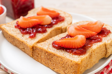 whole wheat bread with strawberry jam and fresh strawberry