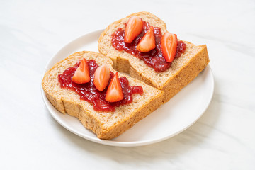 whole wheat bread with strawberry jam and fresh strawberry