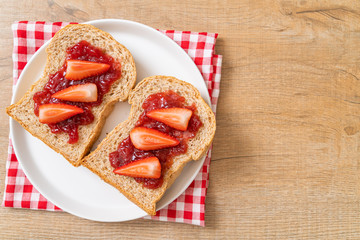whole wheat bread with strawberry jam and fresh strawberry