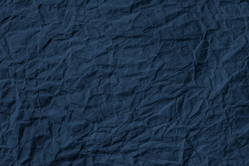 Crumpled dark blue paper textured background