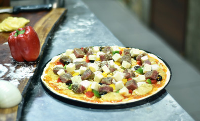 Fresh pizza in kitchen before baking. 