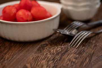 Background Of Blur Focus Of A Bowl Skinless Tomato, Fork And Spoon On The Table