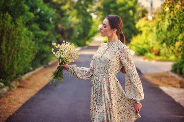 Portrait of a young beautiful girl in a light summer dress