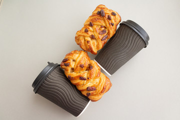 Coffee to go concept. Disposable black cup with spiral texture with black plastic cover and maple pecan on a trendy grey background. Place for text. Flat lay style. Top view