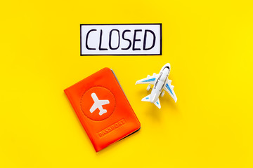 Closed counrty borders - coronovirus quarantine. Airplane and passport on yellow background top view copy space