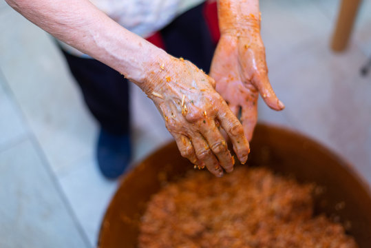 Manos de mujer de edad avanzada limpi&aacute;ndose despu&eacute;s de amasar el relleno con piment&oacute;n durante la elaboraci&oacute;n de morcillas de arroz, blanco y negro. Tomada el 20 de febrero de 2020 en Burgos.