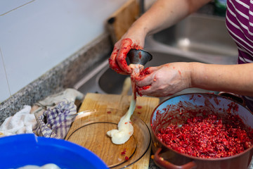 Una mujer rellena una tripa durante la elaboración de morcillas tradicionales de arroz de Burgos....