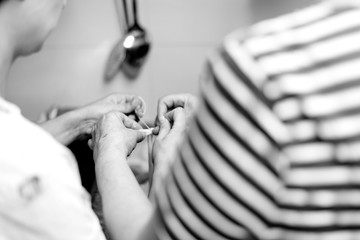 Manos de mujer atando tripas de ternera durante el proceso tradicional de embutido de morcillas de arroz de Burgos, blanco y negro. Tomada el 20 de febrero de 2020 en Burgos, Castilla y León.