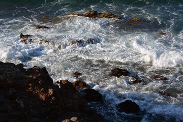 foam next to the stones at the shore