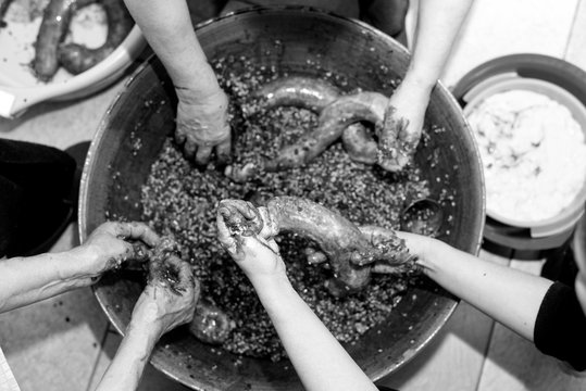 Manos de mujer rellenando tripas durante la elaboraci&oacute;n casera de morcillas de arroz de Burgos seg&uacute;n el m&eacute;todo tradicional, blanco y negro. Tomada el 20 de febrero de 2020 en Burgos, Castilla y Le&oacute;n.