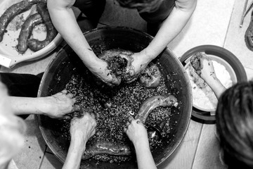Manos de mujer rellenando tripas durante la elaboración casera de morcillas de arroz de Burgos...