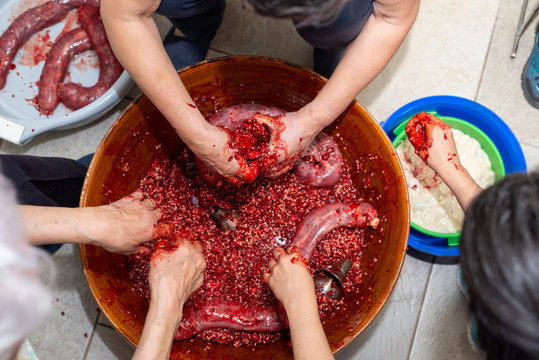 Manos de mujer rellenando tripas de ternera durante la elaboraci&oacute;n casera de morcillas de arroz de Burgos seg&uacute;n el m&eacute;todo tradicional. Tomada el 20 de febrero de 2020 en Burgos, Castilla y Le&oacute;n.