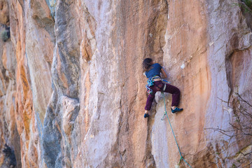 A strong girl climbs a rock, Rock climbing in Turkey.