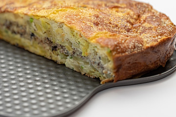 Homemade yeast-free cake on kefir with a filling of canned fish and potatoes, close-up.