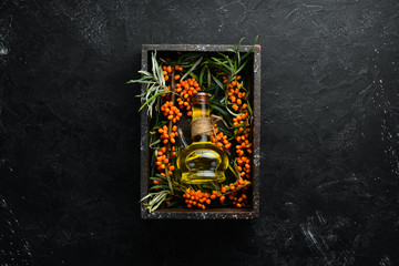 Sea buckthorn oil. Fresh sea buckthorn berries on a twig. Top view. Free space for your text.