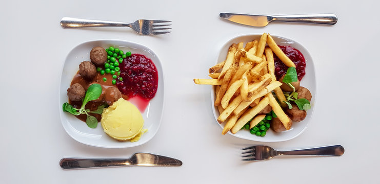 Swedish traditional meatballs with boiled potatoes and sweet potato fries  with cranberry sauce in cafe IKEA. 