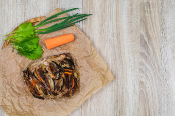 Oven-baked pork slices with vegetables on a wooden table, background
