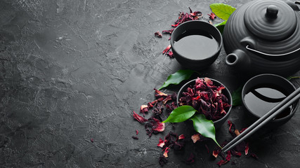 Red Asian traditional tea Hibiscus. On a black stone background. Top view. free space for your text.