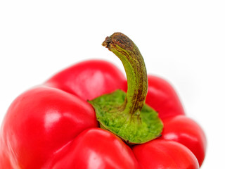 Ripe red bell pepper with a green dried stalk is isolated on a white background. Ingredient for salad, roast, soup and many other recipes.