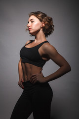 Fototapeta premium Young girl doing yoga on a black background