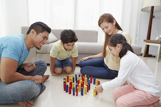 Family of four playing with building blocks