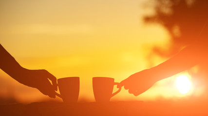 Friends drinking coffee in sunrise time, early morning.