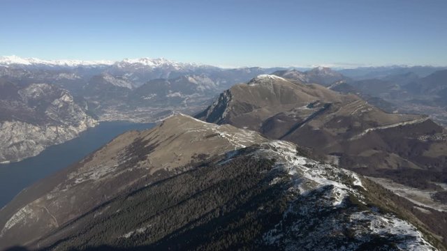 Flying high along mountain ridge in Italian Alps, Lake Garda