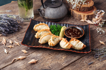 Fried japanese dumplings gedza sauce wooden table