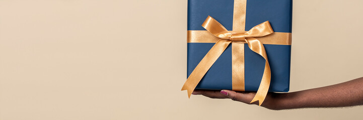 Woman holding a present against a beige background