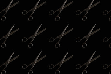 open old scissors isolated on black background pattern