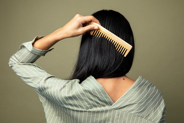 Back view of a woman combing her hair - Powered by Adobe