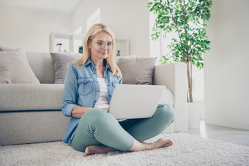 Photo of attractive middle aged domestic lady relaxing sitting comfy floor carpet near couch...