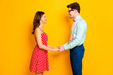 Profile photo of pretty lady handsome guy prom party couple photographing hold arms look eyes wear red dress shirt bowtie pants elegant retro outfit isolated yellow bright color background