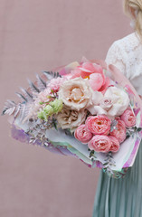 Girl holds a bouquet of flowers. Florist and a bouquet of flowers. Female hands and flowers. Flower shop concepts.