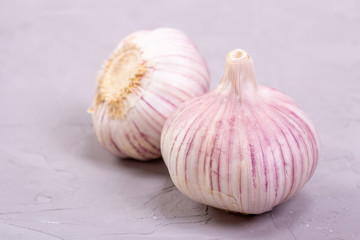 Two heads of garlic close-up on a gray background