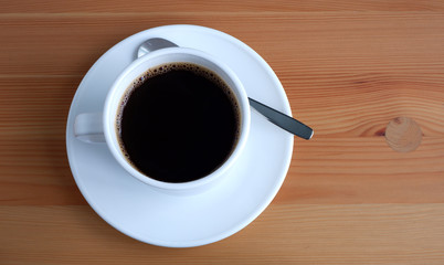 A Cup of coffee on a wooden table. Suitable for advertising backgrounds and mockups