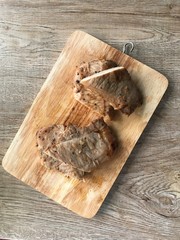 Grilled pork chops, Fried marinated pork steak on wooden background. Top view.