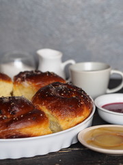 Homemade cake.Buns sprinkled with sesame and sugar syrup with ingredients on a dark wooden table with a gray background.