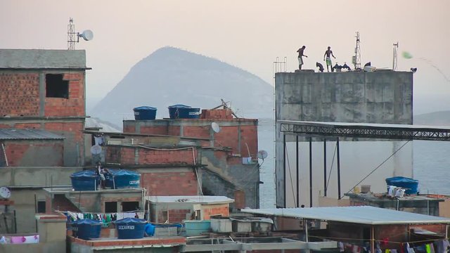children flying a kite on top of a water tank on the Cantagalo hill, Rio de Janeiro, Brazil - May 19, 2015: Children flying a kite on the Cantalago hill in Rio de Janeiro.