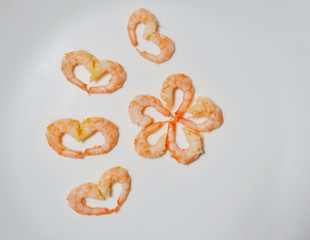 Shrimps laid out in a heart shape on a white background.