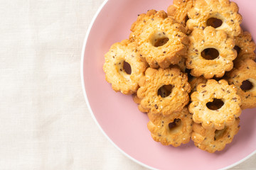 Shortbread in a pink ceramic plate on a light table. A plate of cookies on the table close-up. Top view with space for text