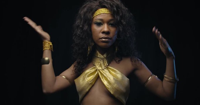 Dancing young woman with curly hair, wearing gold dress, exotic dancer, 4k