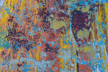 Wall with old multi-colored paint. Saturated bright colors. Peeling, cracks.