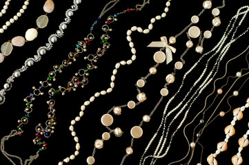 Jewelry on a black background. Different jewelry are folded diagonally in several rows. Accessories...