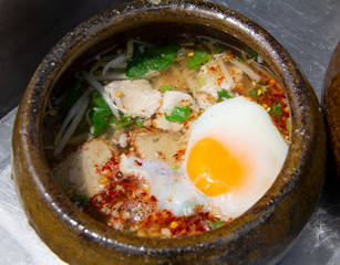 Spicy tom yum noodle in the clay bowl