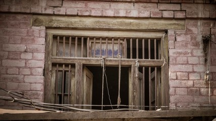 Fototapeta na wymiar Brick wall with frame of wooden window and bars