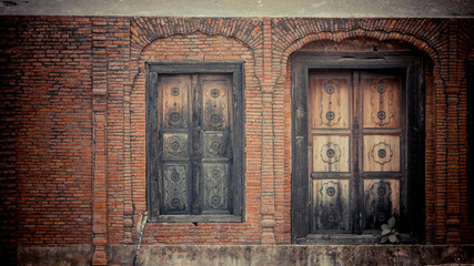 Fototapeta na wymiar brick walls with black window and wooden door