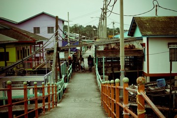 Bridge path with red fence with houses