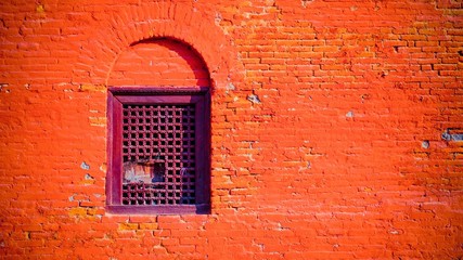 Bright brick wall with wooden windows with holes