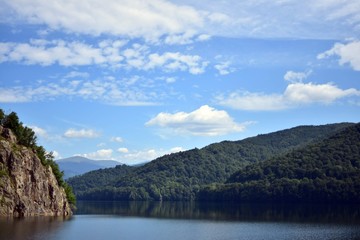lake mirroring rocky mountains with forest fir trees on summer season